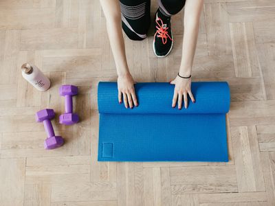 Roll of grey mat and water bottle on floor